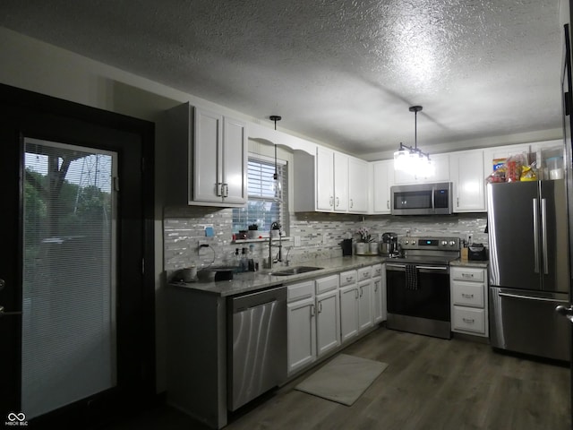 6714 Colleens Way, Indianapolis, IN 46221 - kitchen with appliances with stainless steel finishes, a sink, a textured ceiling, tasteful backsplash, and white cabinetry