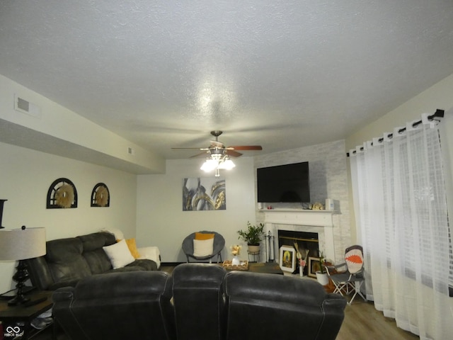6714 Colleens Way, Indianapolis, IN 46221 - living room featuring ceiling fan, a large fireplace, wood finished floors, and a textured ceiling