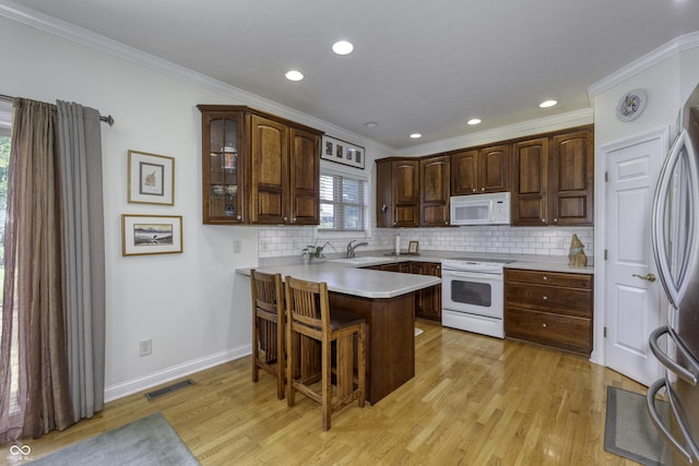 2553 Forest Hills Blvd, Greenwood, IN 46143 - kitchen with white appliances, a sink, a peninsula, ornamental molding, and a kitchen breakfast bar