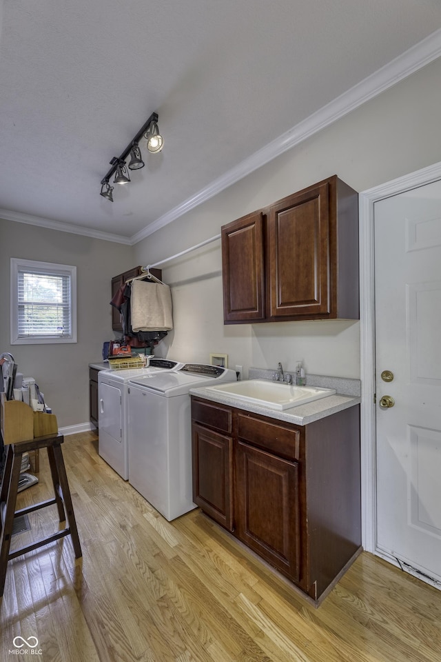 2553 Forest Hills Blvd, Greenwood, IN 46143 - washroom with cabinet space, washer and dryer, crown molding, light wood-style flooring, and rail lighting