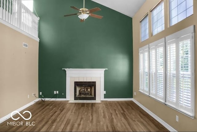 7211 Topp Creek Ct, Indianapolis, IN 46214 - unfurnished living room featuring high vaulted ceiling, ceiling fan, wood finished floors, a tile fireplace, and plenty of natural light