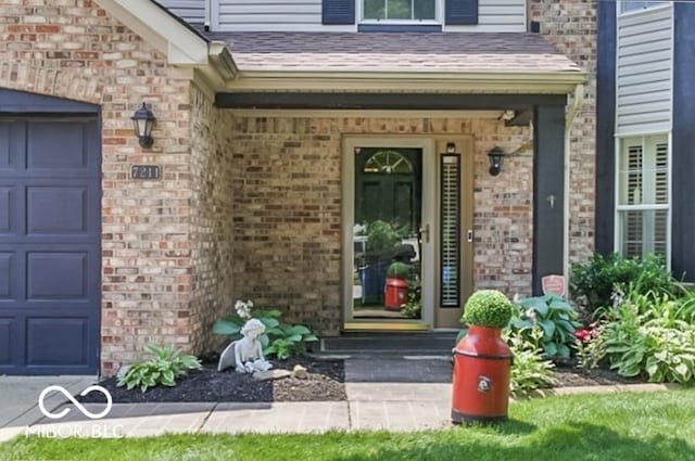 7211 Topp Creek Ct, Indianapolis, IN 46214 - view of exterior entry with an attached garage, brick siding, covered porch, and roof with shingles