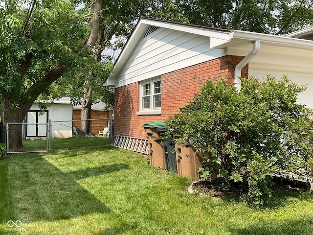 3520 Lantern Ln, Columbus, IN 47203 - view of side of home with brick siding, an attached garage, and a gate