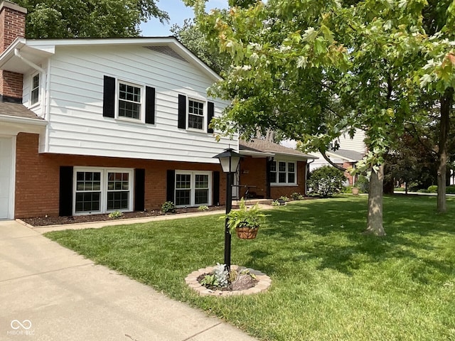3520 Lantern Ln, Columbus, IN 47203 - tri-level home with brick siding, a front yard, a chimney, and a garage