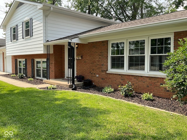 3520 Lantern Ln, Columbus, IN 47203 - split level home with brick siding, a front yard, and a garage