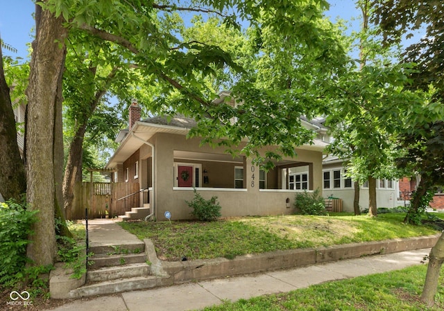 4048 N College Ave, Indianapolis, IN 46205 - view of front of home featuring a chimney, stucco siding, and a front yard