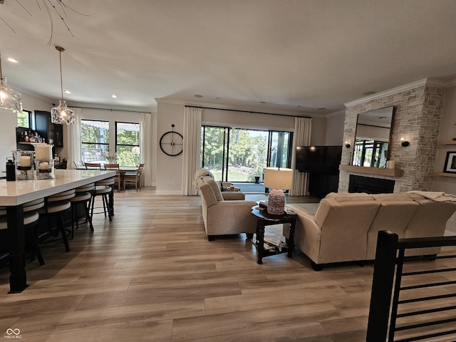 5686 Ellie Ct, Noblesville, IN 46062 - living room with ornamental molding, light wood-style flooring, recessed lighting, baseboards, and a large fireplace