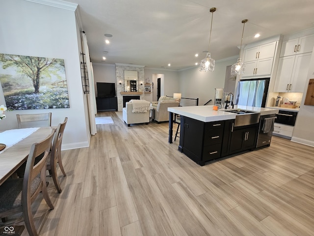 5686 Ellie Ct, Noblesville, IN 46062 - kitchen featuring dark cabinetry, a sink, freestanding refrigerator, light countertops, and white cabinets