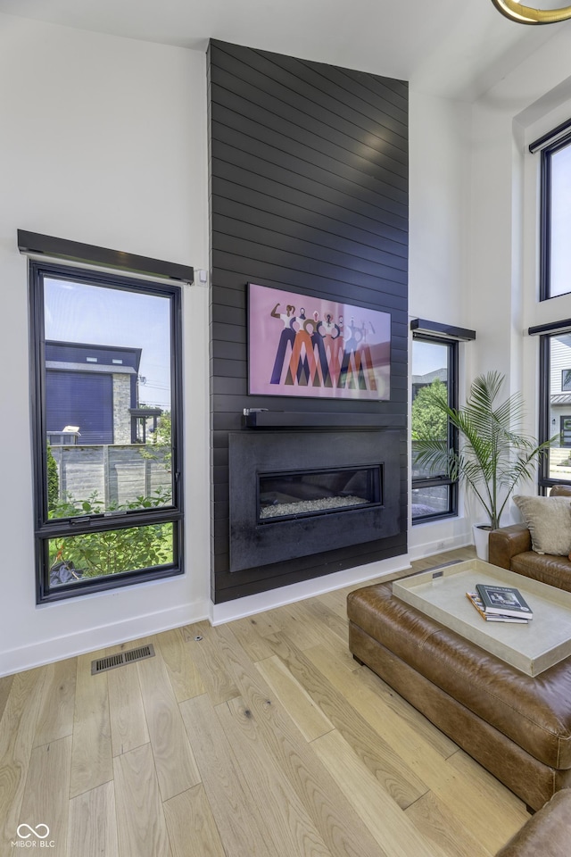 8695 Morgan Dr, Fishers, IN 46038 - living area featuring a large fireplace, wood finished floors, and a towering ceiling