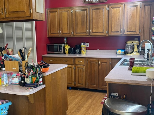 800 N Walnut Hls, Crawfordsville, IN 47933 - kitchen featuring a sink, stainless steel microwave, light countertops, and brown cabinets
