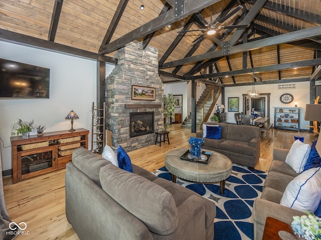 2004 Layton Rd, Anderson, IN 46011 - living room featuring a stone fireplace, wood ceiling with exposed beams, wood finished floors, stairway, and ceiling fan