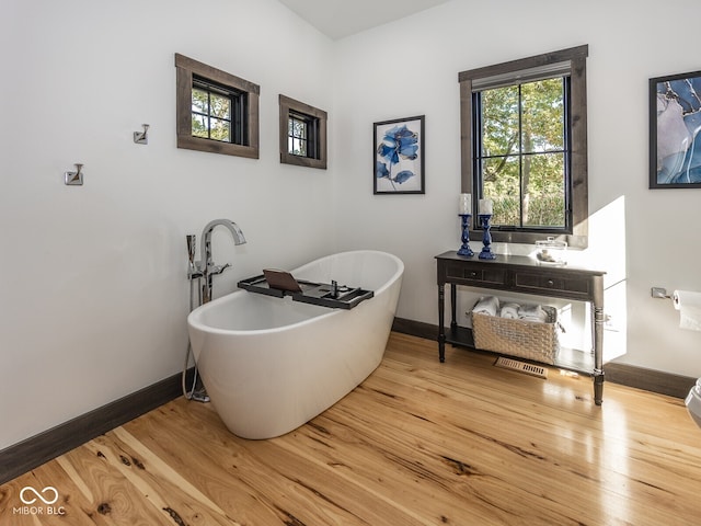 2004 Layton Rd, Anderson, IN 46011 - full bath featuring a soaking tub, baseboards, and wood finished floors