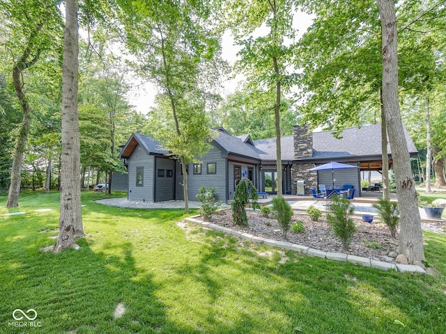 2004 Layton Rd, Anderson, IN 46011 - back of property with a chimney, a lawn, and a patio
