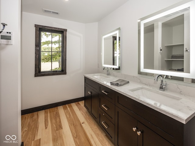 2004 Layton Rd, Anderson, IN 46011 - bathroom featuring double vanity, wood finished floors, and baseboards