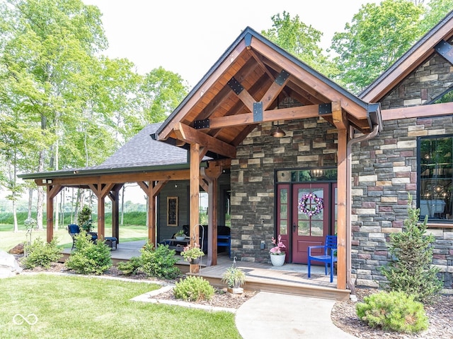 2004 Layton Rd, Anderson, IN 46011 - view of exterior entry with stone siding, a shingled roof, and a yard