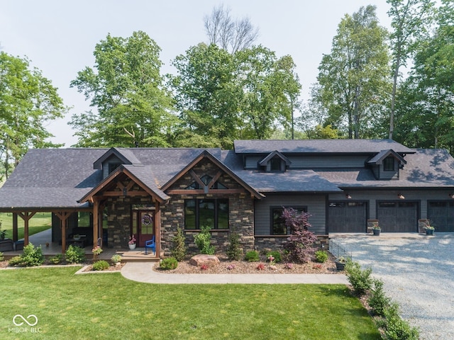 2004 Layton Rd, Anderson, IN 46011 - view of front of property featuring stone siding, driveway, a front lawn, an attached garage, and covered porch