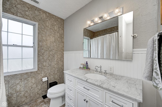 8436 E 56th St, Indianapolis, IN 46216 - bathroom with vanity, a textured ceiling, wainscoting, and a shower with shower curtain