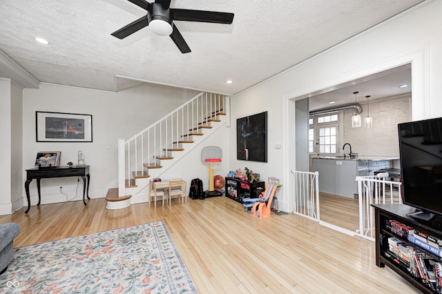 8436 E 56th St, Indianapolis, IN 46216 - living area featuring light wood-style flooring, a textured ceiling, a ceiling fan, stairs, and recessed lighting