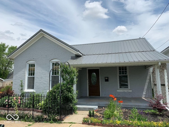328 N Carver St, Greensburg, IN 47240 - view of front of property featuring brick siding, covered porch, and metal roof