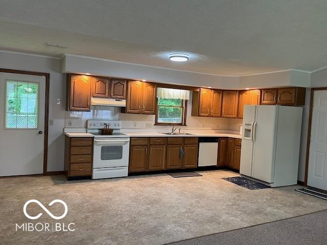 9451 S Amanda Dr, Claypool, IN 46510 - kitchen featuring white appliances, under cabinet range hood, brown cabinetry, plenty of natural light, and crown molding