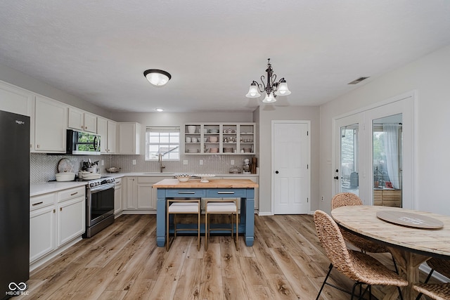 293 E Quail Wood Ln, Westfield, IN 46074 - kitchen with appliances with stainless steel finishes, butcher block counters, a chandelier, tasteful backsplash, and white cabinetry