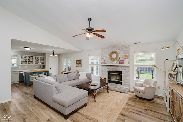 293 E Quail Wood Ln, Westfield, IN 46074 - living room featuring light wood finished floors, a fireplace, plenty of natural light, and vaulted ceiling