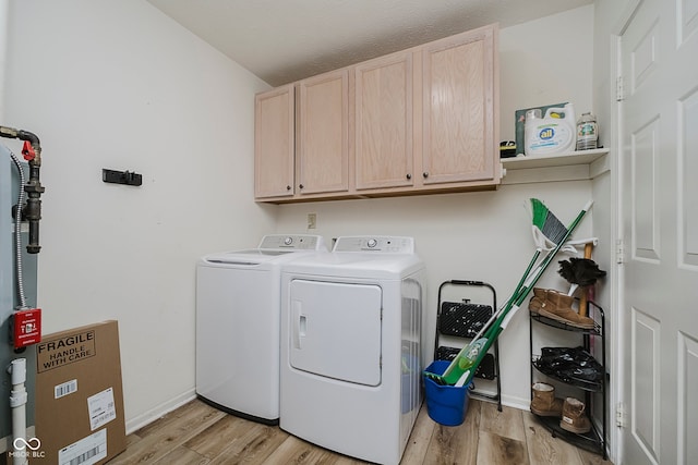 293 E Quail Wood Ln, Westfield, IN 46074 - laundry room with washing machine and dryer, cabinet space, and light wood-style flooring