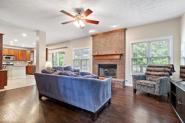 15515 Alameda Pl, Westfield, IN 46074 - living area featuring dark wood finished floors, a ceiling fan, a brick fireplace, a textured ceiling, and recessed lighting