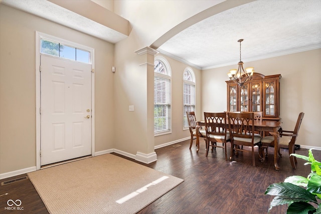 15515 Alameda Pl, Westfield, IN 46074 - entrance foyer with arched walkways, a chandelier, ornamental molding, dark wood-type flooring, and a textured ceiling