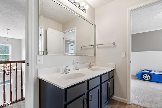 15515 Alameda Pl, Westfield, IN 46074 - full bathroom featuring a textured ceiling, double vanity, plenty of natural light, a chandelier, and baseboards