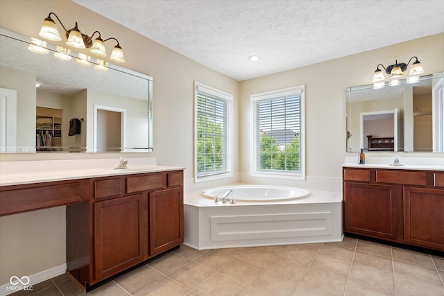 15515 Alameda Pl, Westfield, IN 46074 - bathroom with two vanities, a garden tub, tile patterned floors, a textured ceiling, and a spacious closet