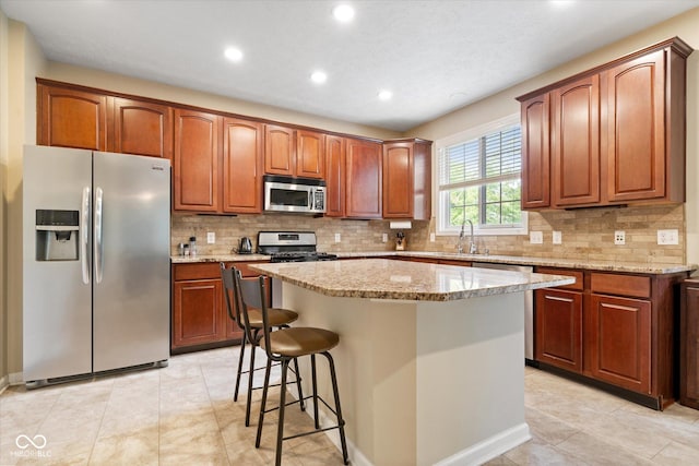15515 Alameda Pl, Westfield, IN 46074 - kitchen featuring stainless steel appliances, light stone countertops, recessed lighting, a center island, and backsplash