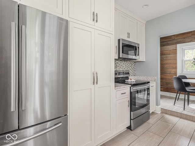 4455 Central Ave, Indianapolis, IN 46205 - kitchen featuring stainless steel appliances, decorative backsplash, light stone counters, white cabinets, and recessed lighting