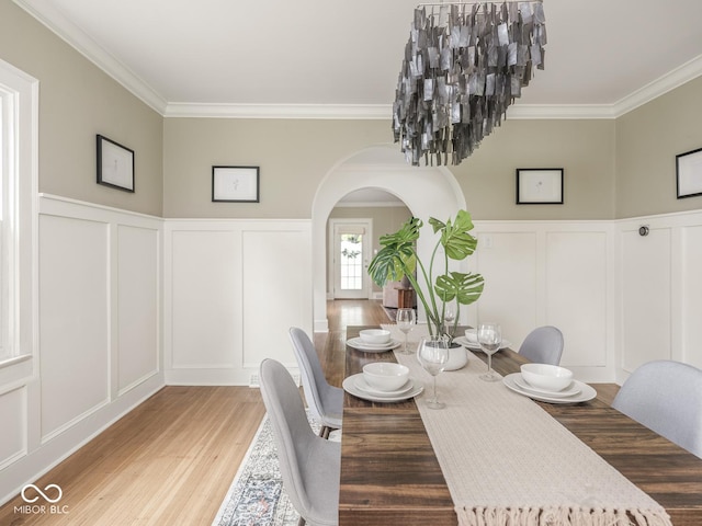 4455 Central Ave, Indianapolis, IN 46205 - dining room with a decorative wall, arched walkways, ornamental molding, wood finished floors, and a wainscoted wall