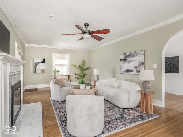 4455 Central Ave, Indianapolis, IN 46205 - living room featuring arched walkways, a ceiling fan, wood finished floors, baseboards, and crown molding