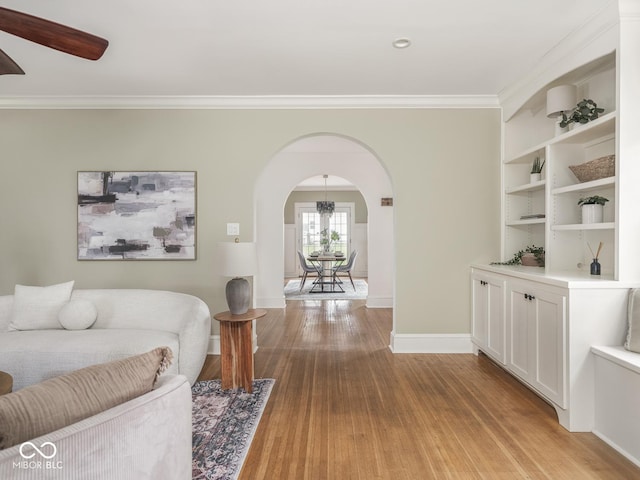 4455 Central Ave, Indianapolis, IN 46205 - living room featuring arched walkways, light wood-style flooring, baseboards, crown molding, and a chandelier