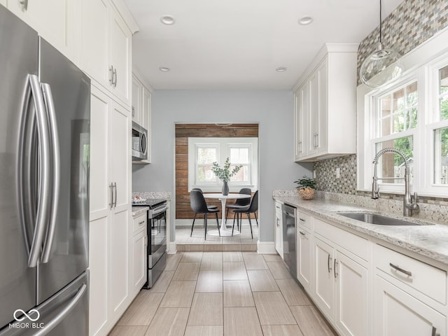 4455 Central Ave, Indianapolis, IN 46205 - kitchen featuring stainless steel appliances, a sink, white cabinets, recessed lighting, and light stone countertops