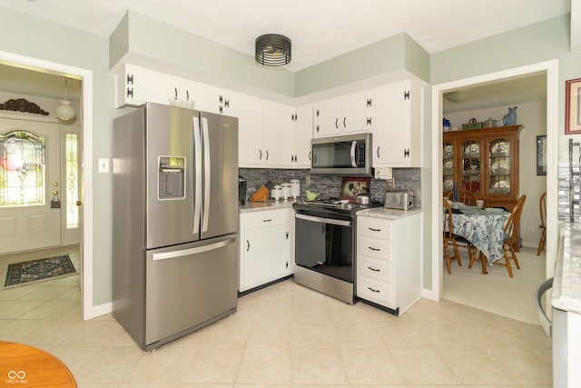 12014 Briar Way Center Dr, Indianapolis, IN 46126 - kitchen with appliances with stainless steel finishes, decorative backsplash, light tile patterned floors, white cabinetry, and baseboards
