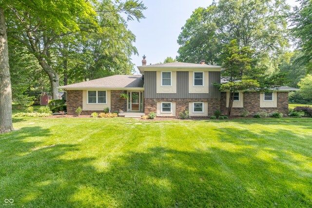 12014 Briar Way Center Dr, Indianapolis, IN 46126 - split level home with a chimney, a front yard, and brick siding