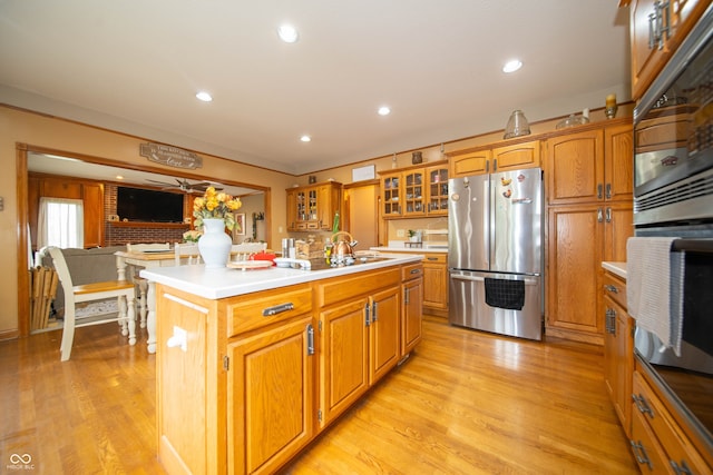 1145 Forest Commons Dr, Avon, IN 46123 - kitchen with appliances with stainless steel finishes, a kitchen island with sink, light countertops, light wood-style floors, and recessed lighting