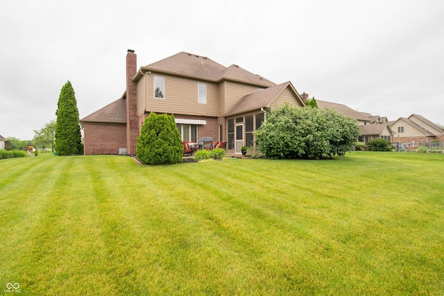 1145 Forest Commons Dr, Avon, IN 46123 - back of property with a chimney, a sunroom, and a yard