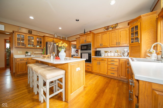 1145 Forest Commons Dr, Avon, IN 46123 - kitchen featuring black appliances, a sink, a kitchen island with sink, light countertops, and recessed lighting