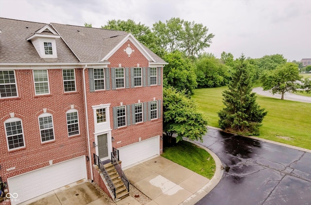 755 Ivy Ln, Carmel, IN 46032 - view of front of home featuring a garage, driveway, brick siding, roof with shingles, and a front lawn