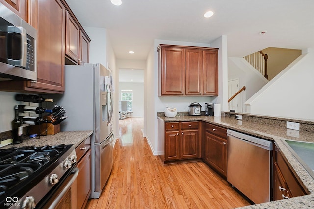 755 Ivy Ln, Carmel, IN 46032 - kitchen featuring stainless steel appliances, light wood-style floors, light stone counters, recessed lighting, and brown cabinetry