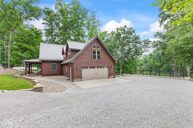 2540 S Annapolis Rd, Rockville, IN 47872 - view of front of home featuring gravel driveway, faux log siding, a garage, metal roof, and view of scattered trees