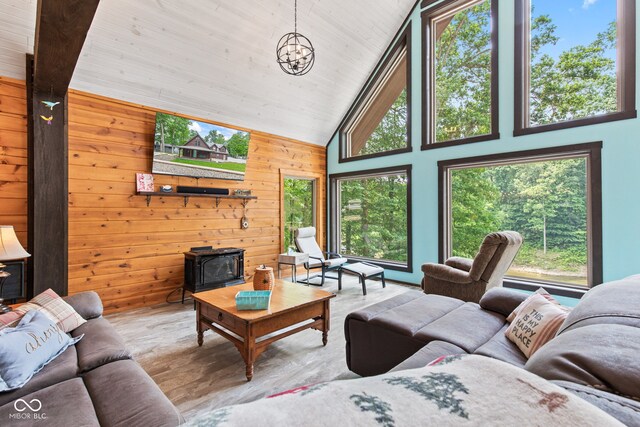 2540 S Annapolis Rd, Rockville, IN 47872 - living area featuring healthy amount of natural light, a wood stove, wood walls, wood finished floors, and a chandelier