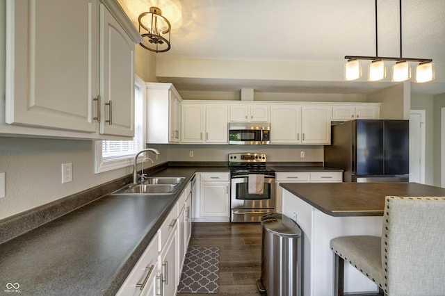 19187 Outer Bank Rd, Noblesville, IN 46062 - kitchen with stainless steel appliances, dark countertops, a sink, a kitchen bar, and white cabinetry