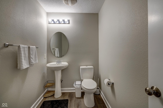 19187 Outer Bank Rd, Noblesville, IN 46062 - half bathroom with wood finished floors, toilet, a sink, a textured ceiling, and baseboards