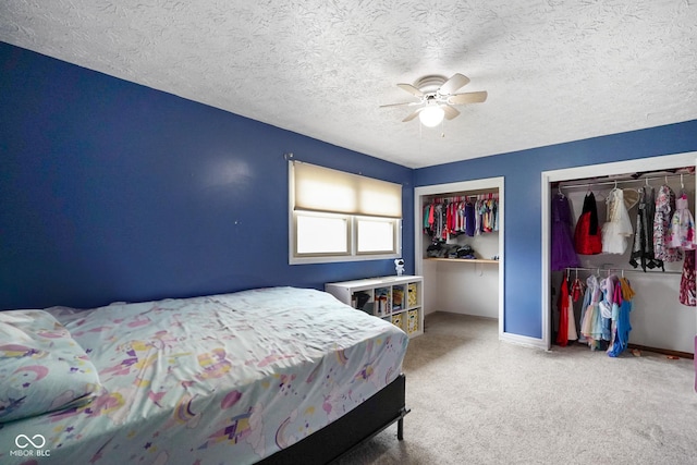 955 Wood Creek Pl, Greenwood, IN 46142 - carpeted bedroom with multiple closets, a ceiling fan, and a textured ceiling