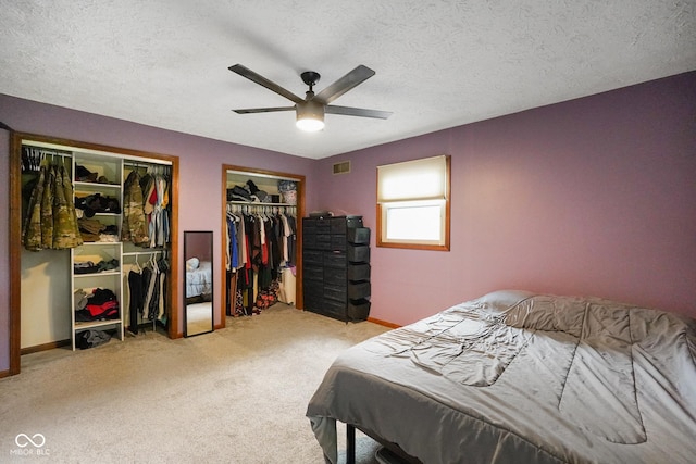 955 Wood Creek Pl, Greenwood, IN 46142 - carpeted bedroom with multiple closets, a textured ceiling, baseboards, and ceiling fan